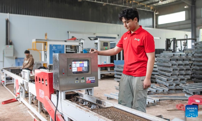 A staff member conducts intelligent seedling cultivation on a machine at a cooperative in Liangping District, southwest China's Chongqing, on March 27, 2026. (Photo by Xiong Wei/Xinhua)

