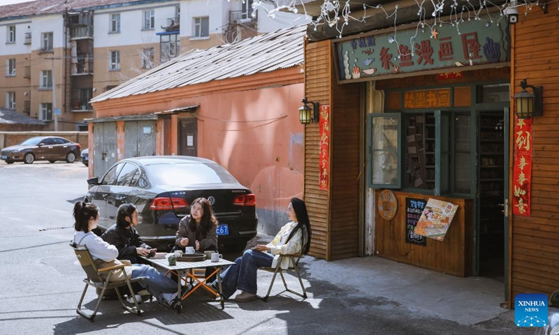 Ma Ruofan (1st R) and book lovers enjoy coffee outside Fanmo Bookstore in Changchun, northeast China's Jilin Province, April 15, 2026. 
