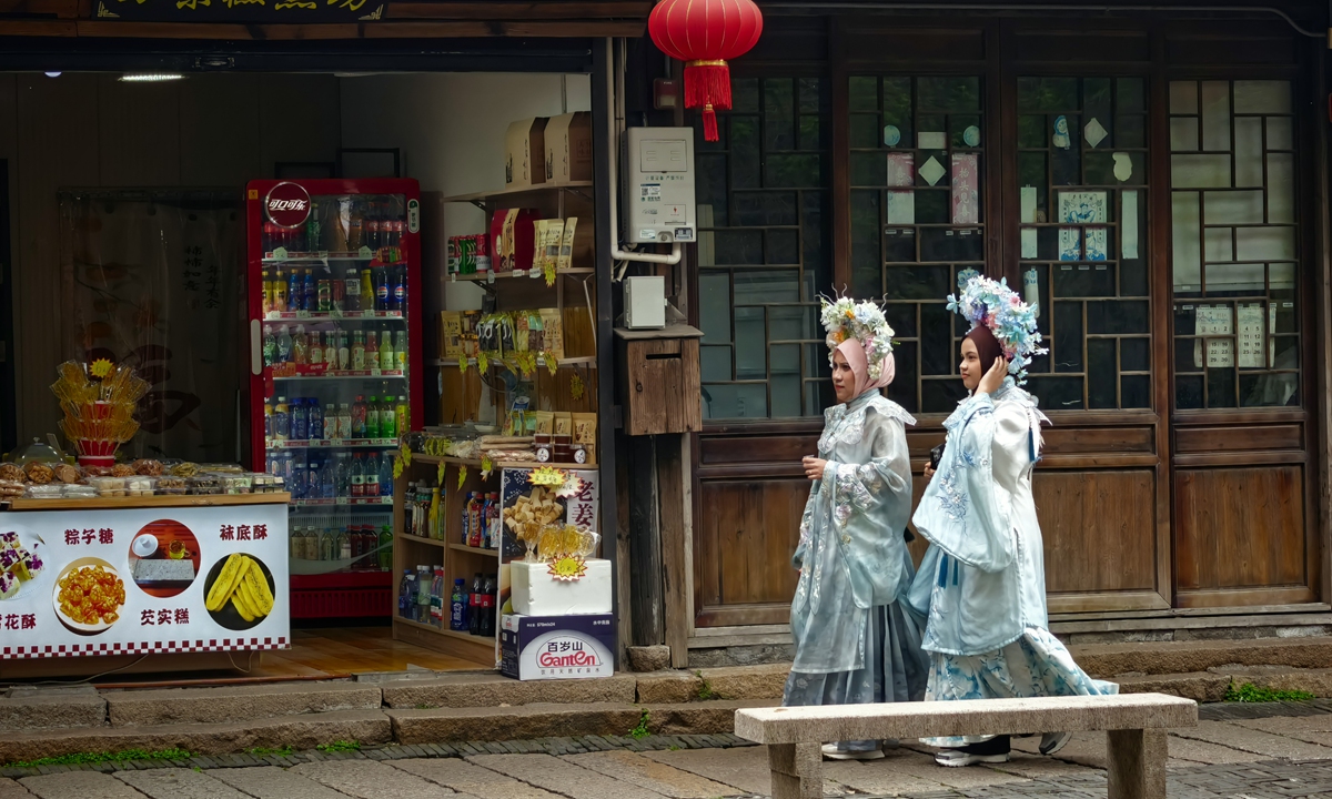 Foreign tourists dressed in traditional Chinese costumes wander through Zhujiajiao, a thousand-year-old town in Qingpu District, east China's Shanghai. Photo: Liu Yang/GT