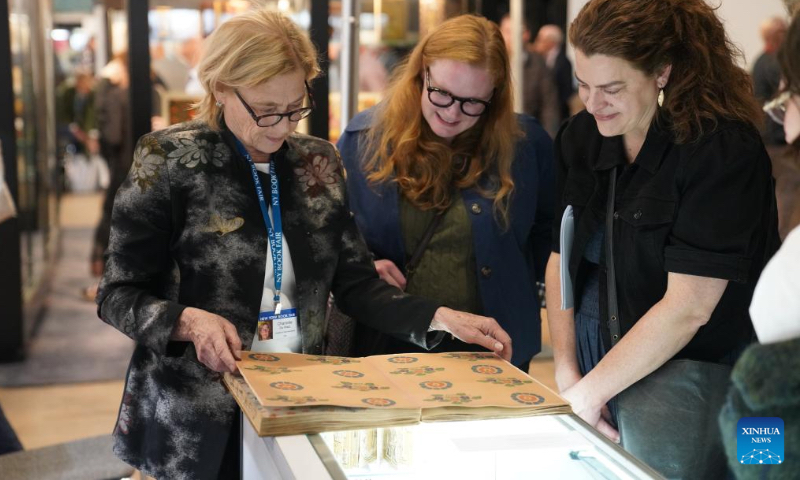 A bookseller introduces a book about patterns and color to visitors at the New York International Antiquarian Book Fair in New York, the United States, on April 30, 2026. The annual book fair kicked off here on Thursday, and will last until May 3. (Xinhua/Zhang Fengguo)