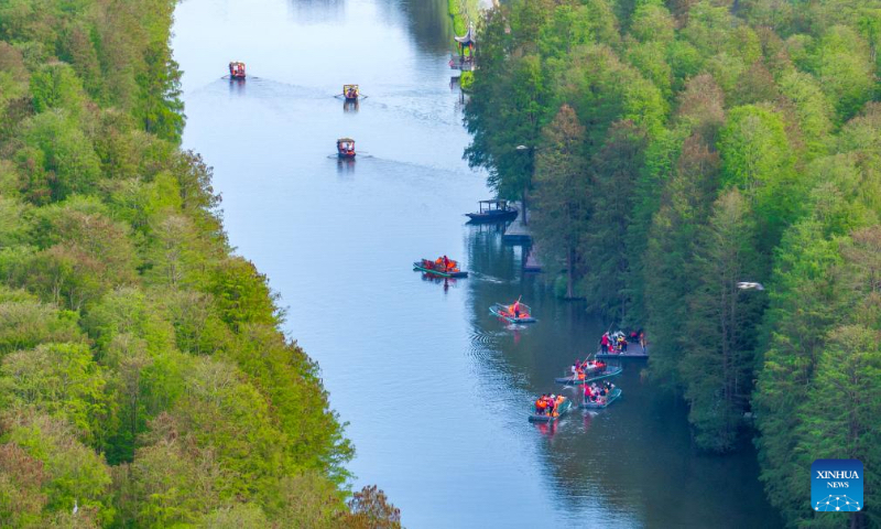 A drone photo taken on May 2, 2026 shows tourists viewing scenery by rafts at a national wetland park in Xinghua City, east China's Jiangsu Province. People across the country are going outdoors to enjoy the five-day May Day holiday, which began on May 1. (Photo by Shi Daozhi/Xinhua)