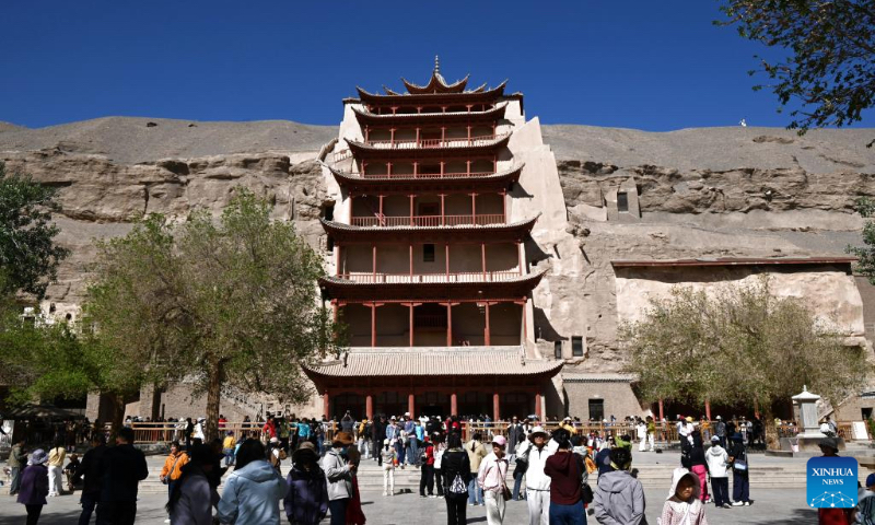 Tourists visit the Mogao Grottoes in Dunhuang City, northwest China's Gansu Province, on May 2, 2026. People across the country are going outdoors to enjoy the five-day May Day holiday, which began on May 1. (Photo by Zhang Xiaoliang/Xinhua)