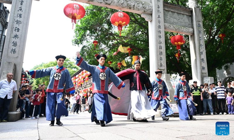 Actors of Minju Opera stage a flash mob performance in the Shangxiahang traditional block in Fuzhou, southeast China's Fujian Province, May 2, 2026. Local authorities have introduced a series of diverse programs and events that enable tourists to experience the charm of traditional culture and custom during the May Day holiday that started on May 1. (Xinhua/Lin Shanchuan)