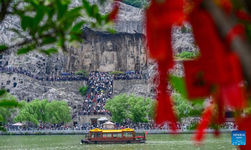 Tourists visit the Longmen Grottoes in Luoyang City, central China's Henan Province, on May 2, 2026. People across the country are going outdoors to enjoy the five-day May Day holiday, which began on May 1. (Photo by Li Weichao/Xinhua)