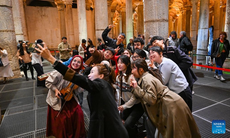 Members of the Nanjing University's traditional instrument orchestra from China and students of Bogazici University pose for a group photo at Basilica Cistern in Istanbul, Türkiye, April 22, 2026. Nanjing University's traditional instrument orchestra, in collaboration with the Confucius Institute at Bogazici University, staged a flash mob performance of Chinese folk music here on Wednesday, attracting many visitors. (Xinhua/Liu Lei)

