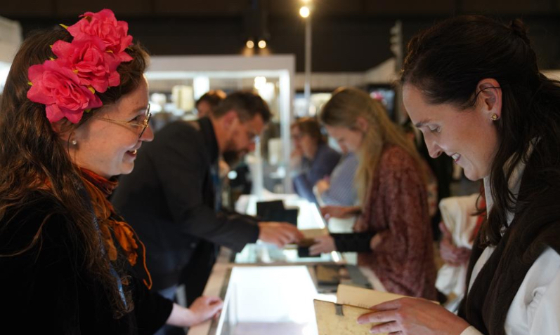 A visitor talks with an exhibitor at the New York International Antiquarian Book Fair in New York, the United States, on April 30, 2026. The annual book fair kicked off here on Thursday, and will last until May 3. (Xinhua/Zhang Fengguo)