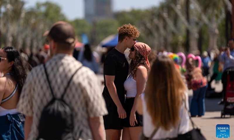 A man kisses his companion on the Passeig de Sant Joan in Barcelona, Spain, April 23, 2026. Large crowds filled the Spanish city of Barcelona on Thursday as people took to the streets to celebrate Sant Jordi, a traditional festival combining romance and reading. (Photo by Joan Gosa/Xinhua)