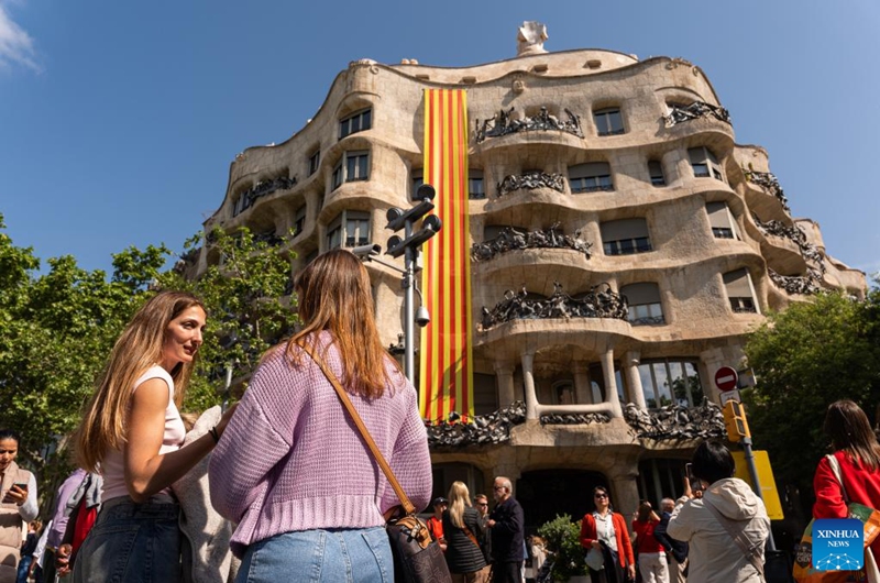 People visit La Pedrera, or Casa Mila, in Barcelona, Spain, April 23, 2026. Large crowds filled the Spanish city of Barcelona on Thursday as people took to the streets to celebrate Sant Jordi, a traditional festival combining romance and reading. (Photo by Joan Gosa/Xinhua)