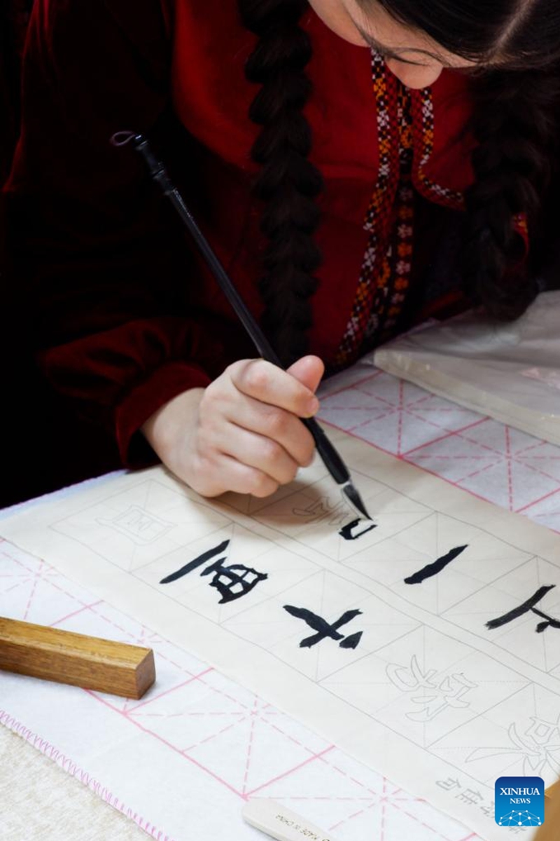 A student tries Chinese calligraphy at the 2026 International Chinese Language Day event in Ashgabat, Turkmenistan, April 23, 2026. A celebration event marking the 2026 International Chinese Language Day was held here Thursday. (Photo by Cui Jiaxin/Xinhua)