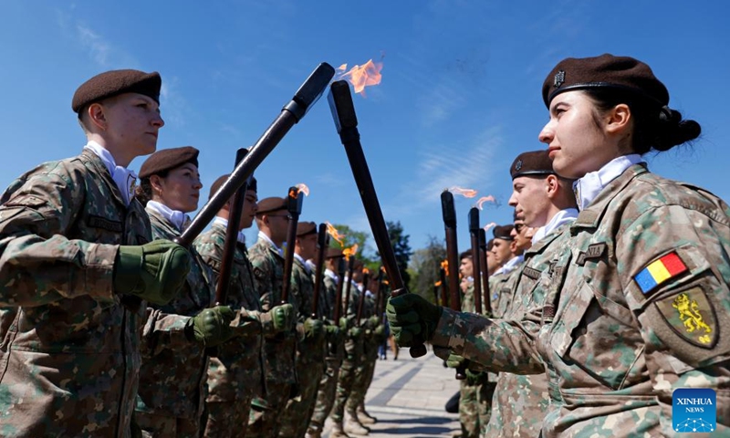 Soldiers light torches during a ceremony marking Romania's Land Forces Day at the Tomb of Unknown Soldier in Bucharest, Romania, April 23, 2026. Photo: Xinhua