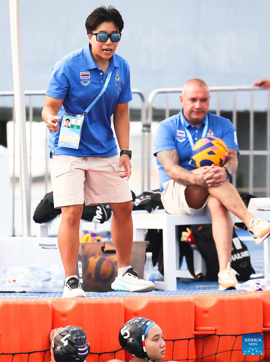 Sarocha Rewrujirek (L), head coach of Thailand, instructs players during the water polo women's round-robin final match between China and Thailand at the 6th Asian Beach Games in Sanya, south China's Hainan Province, April 23, 2026. (Xinhua/Zhu Weixi)