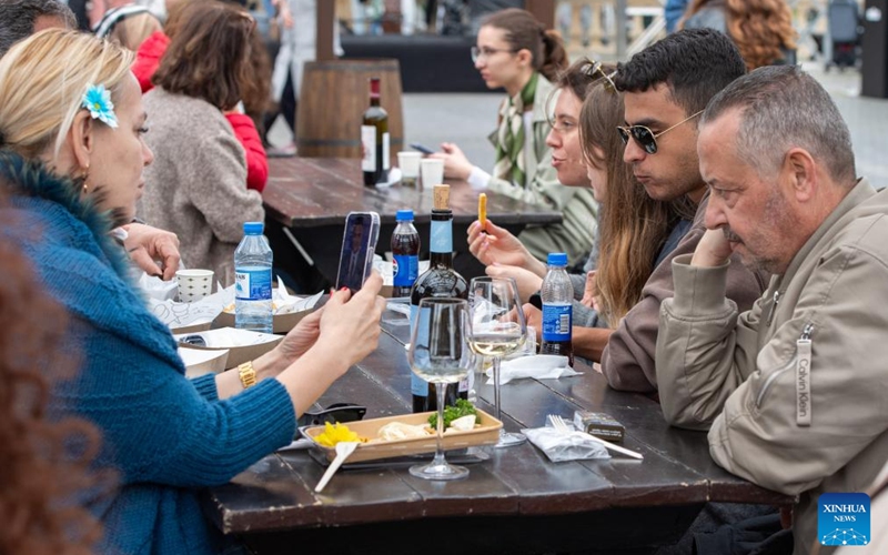 People relax and taste wine during the Jazz and Wine Festival at a seaside park in Baku, Azerbaijan, April 25, 2026. The ten-day event integrates Azerbaijan's indigenous wine-making traditions with musical art, bringing a relaxing and vibrant vibe to the city and drawing numerous locals and tourists for leisure and wine tasting. (Xinhua/Chen Junfeng)