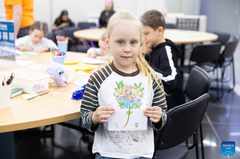 A young girl displays her drawing of rhododendrons during the rhododendron festival in Vladivostok, Russia, April 25, 2026. The rhododendron festival was held here on Saturday to promote rhododendron-themed tourism and enhance its appeal to tourists. (Photo by Andrey Matveenko/Xinhua)