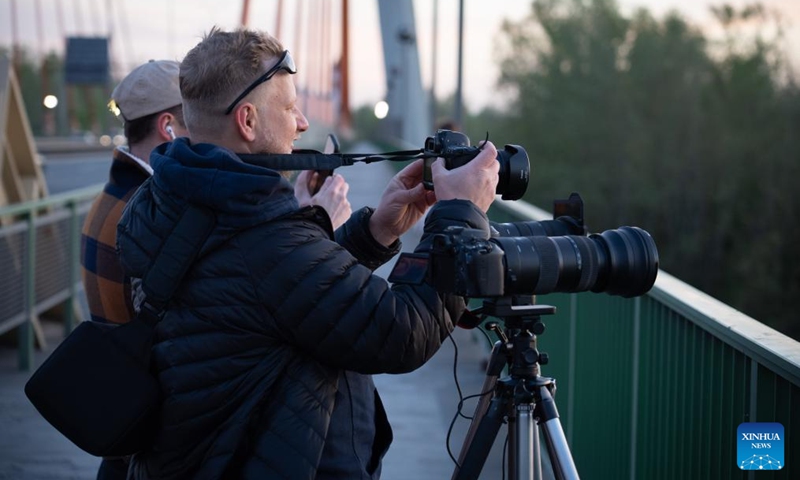 People take photos of the sunset scenery from a bridge over the Vistula River in Warsaw, Poland, April 23, 2026. (Photo by Jaap Arriens/Xinhua)