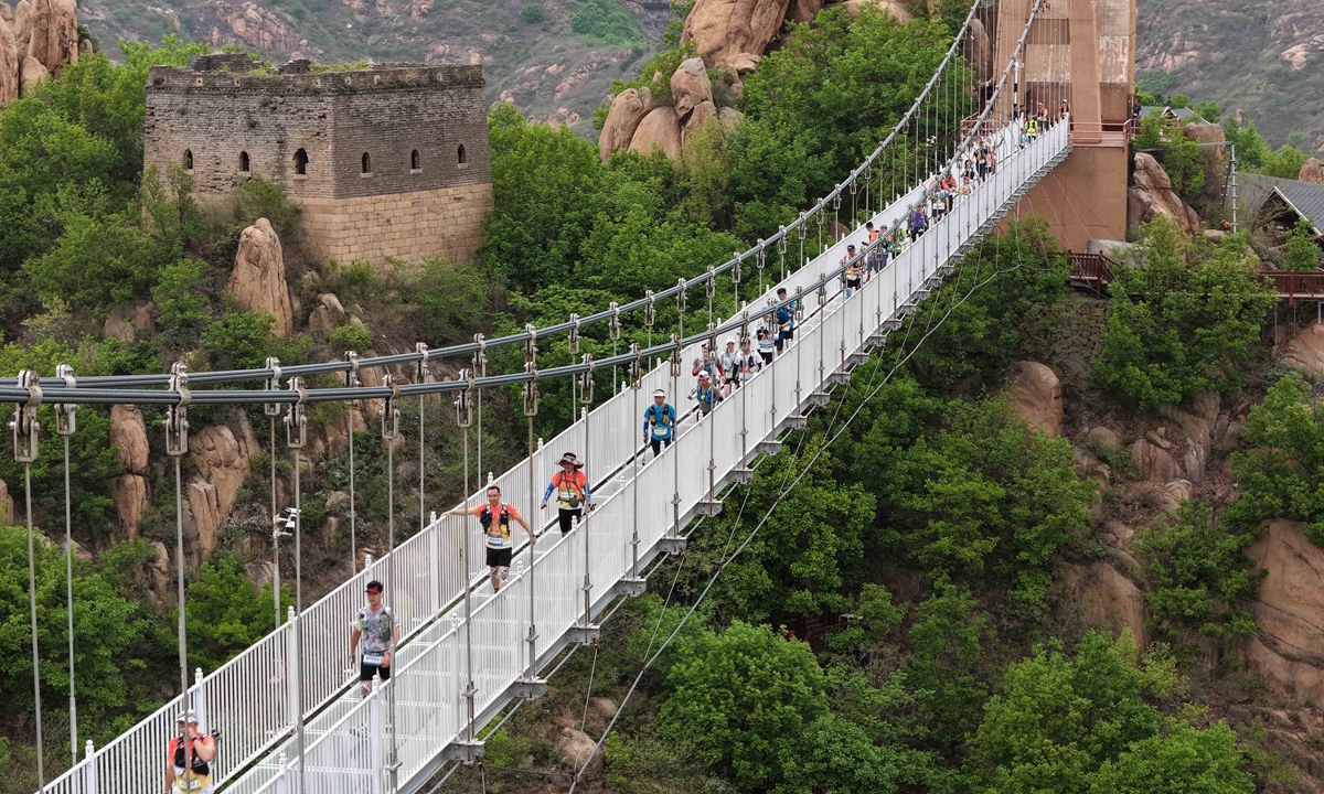 Competitors race across a bridge for the Funing station of the 2026 China Mountain Trail Open in Funing, Qinhuangdao, North China's Hebei Province, on April 26, 2026. Featuring four categories - 50km, 30km, 15km and 5km - and balancing professional competition and public participation, the event attracted more than 3,000 cross-country running enthusiasts from all over China. Photo: VCG