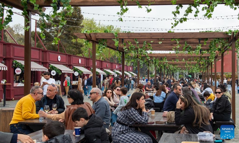 People relax and enjoy delicacies during the Jazz and Wine Festival at a seaside park in Baku, Azerbaijan, April 25, 2026. The ten-day event integrates Azerbaijan's indigenous wine-making traditions with musical art, bringing a relaxing and vibrant vibe to the city and drawing numerous locals and tourists for leisure and wine tasting. (Xinhua/Chen Junfeng)