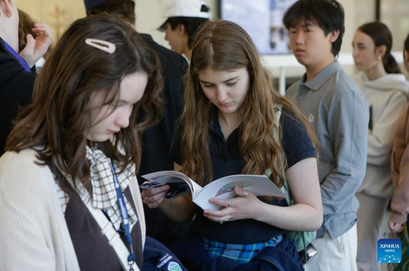 A student looks at a university brochure during the Global Universities Fair in Vancouver, British Columbia, Canada, April 25, 2026. Representatives from different universities and colleges from multiple countries attended the event, offering students and parents opportunities to explore international higher education options and admission pathways. (Photo by Liang Sen/Xinhua)