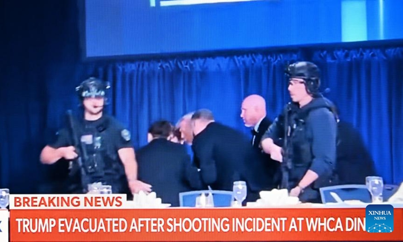 This photo taken on April 25, 2026 shows a screen displaying U.S. President Donald Trump being evacuated from the White House Correspondents' Dinner in Washington, D.C., the United States. U.S. President Donald Trump has been evacuated from the White House Correspondents' Dinner after what appears to be a security incident at the event, according to a live broadcast on Saturday night. Trump confirmed that the shooter at the White House Correspondents' Dinner is in custody in his Truth Social post. (Xinhua/Li Rui)