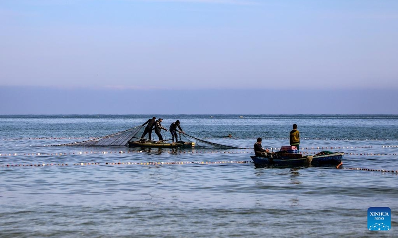 Palestinian fishermen are seen fishing on their boats near the Gaza port in Gaza City, on April 24, 2026. (Photo by Rizek Abdeljawad/Xinhua)