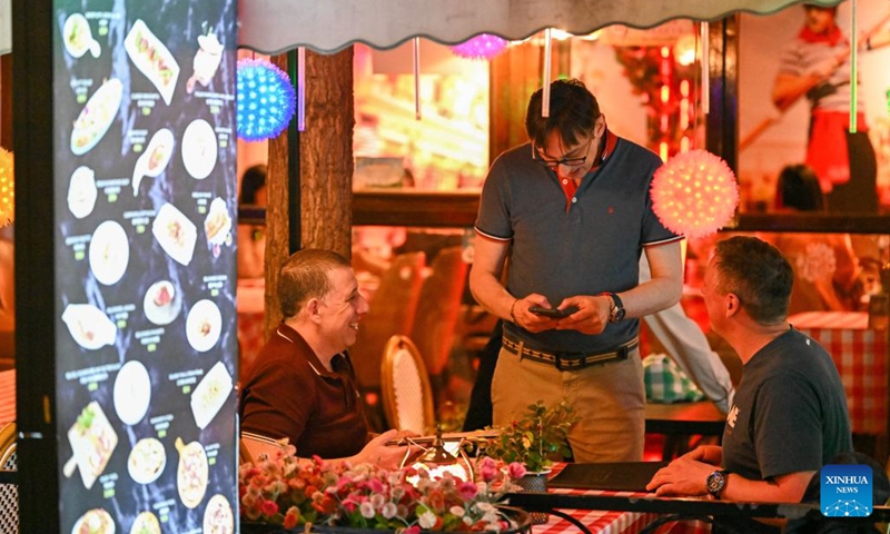 Foreign tourists order food at a restaurant in the Italian Style Area of Tianjin, north China, April 24, 2026. In recent years, Tianjin has become a popular tourist destination, as the city keeps enriching its nighttime experience by expanding tourism scenarios and diversifying business formats. (Xinhua/Sun Fanyue)