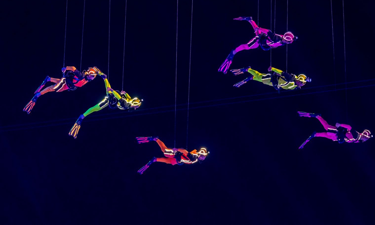 Wire-suspended performers in fluorescent diving suits perform at the Games' opening ceremony. Photo: Courtesy of the directing team