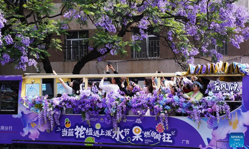 Tourists take a sightseeing bus to enjoy jacaranda blossoms in Kunming, southwest China's Yunnan Province, April 26, 2026. (Photo by Liang Zhiqiang/Xinhua)

