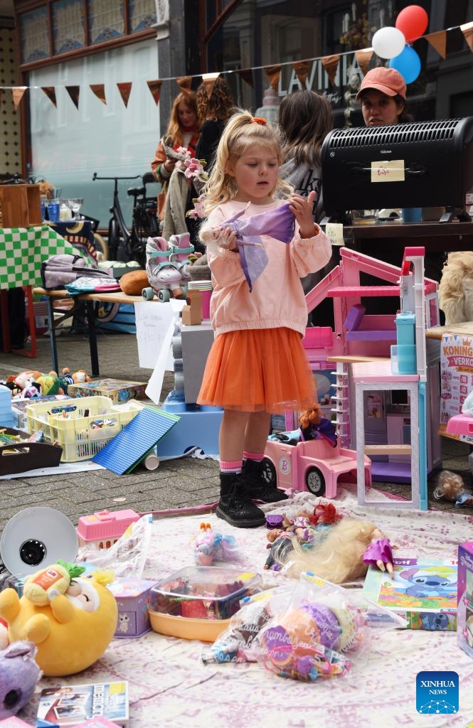A girl selects toys at a flea market in The Hague, the Netherlands, on April 27, 2026. Flea markets were held across the Netherlands on King's Day, which is celebrated on April 27, the birthday of Dutch King Willem-Alexander. (Xinhua/Shao Haijun)

