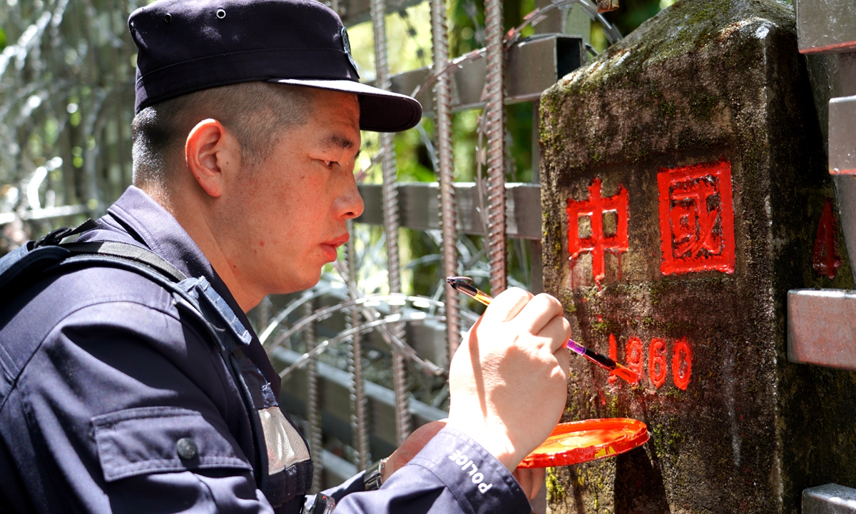 A police officer redraws the lettering on boundary marker 41 in Dulongjiang, Yunnan. Photo: Courtesy of Dulongjiang Frontier Police Station