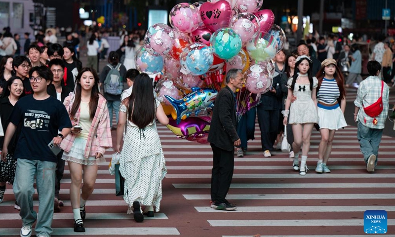 Tourists cross a road at a commercial district in Changsha, central China's Hunan Province, April 25, 2026.

Changsha at night features diverse modes of business: live-streaming, band performance, period costume photography and night-market food, all contributing to the nighttime economic vitality of the city. (Xinhua/Liu Jie)