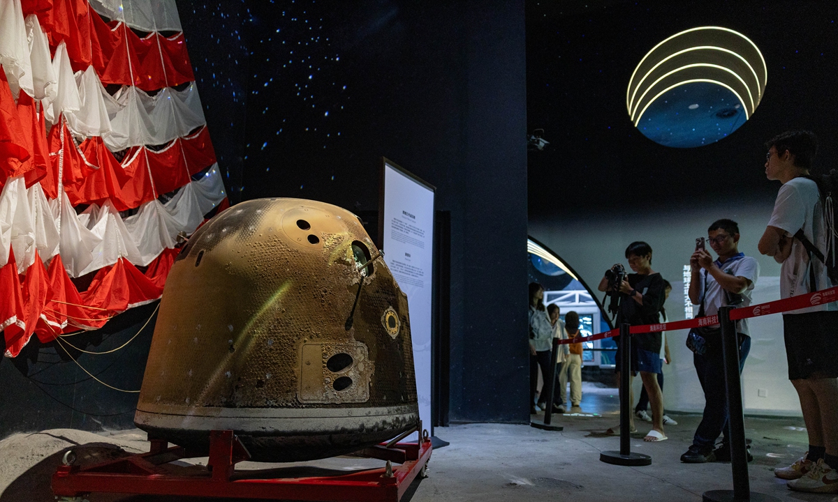 Visitors view and photograph the return capsule and parachute of China's Chang'e-5 lunar probe, making their debut public display in Hainan at the newly opened Hainan Science and Technology Museum in Haikou on April 29. Photo: IC