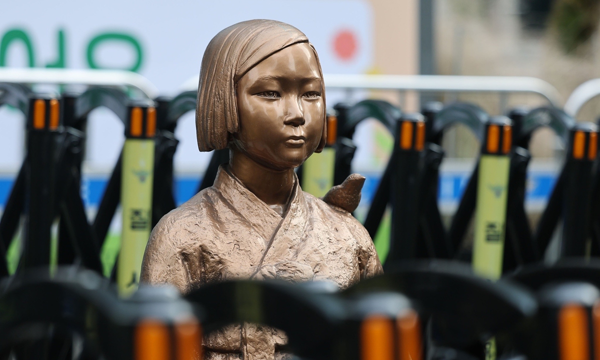 A statue of a seated girl symbolizing 