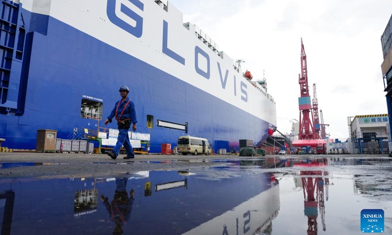 A staff member walks past car carrier Glovis Leader in Guangzhou, south China's Guangdong Province, April 28, 2026. A car carrier with a maximum capacity of 10,800 car equivalent units, described as the world's largest of its kind, was delivered Tuesday in the southern Chinese city of Guangzhou.

