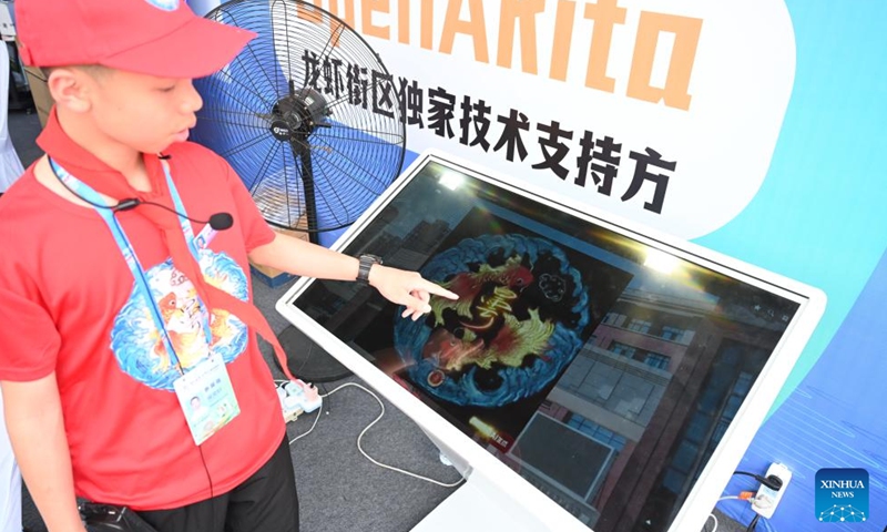 A middle school student introduces a drawing meaning good luck for exams at an artificial intelligence (AI) market in Fuzhou Strait International Conference & Exhibition Center, Fuzhou, southeast China's Fujian Province, April 28, 2026. The AI market kicked off here ahead of the 9th Digital China Summit, which will convene in Fuzhou from April 29 to 30. (Xinhua/Lin Shanchuan)


