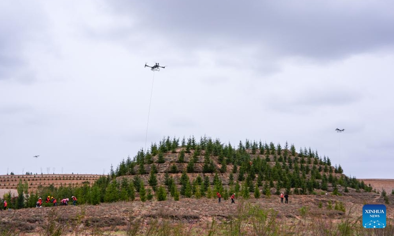 Drones transport saplings at a park in Lanzhou, northwest China's Gansu Province, April 27, 2026. Over the past few days, several drones shuttle back and forth over more than 2,300 mu (about 153 hectares) of barren hills here to accurately lift saplings and efficiently assist afforestation operations.

