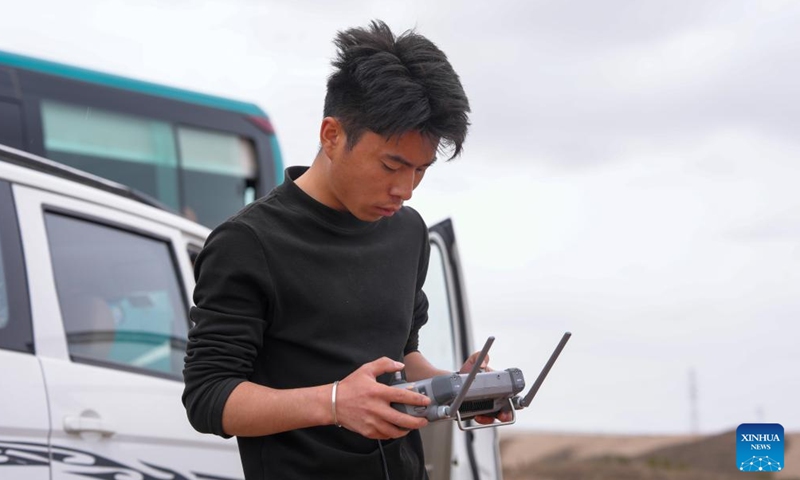 A staff member operates a drone to transport a sapling at a park in Lanzhou, northwest China's Gansu Province, April 27, 2026. 