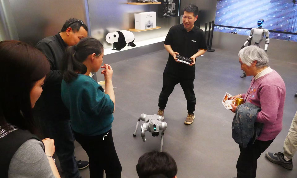 People interact with a GO2 robot dog at the Unitree offline store in Beijing on April 30, 2026. Photo: Tao Mingyang/GT