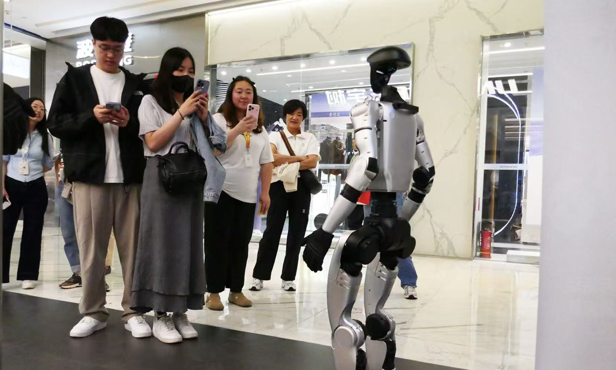 People take photos of the G1 humanoid robot at the Unitree offline store in Beijing on April 30, 2026. Photo: Tao Mingyang/GT