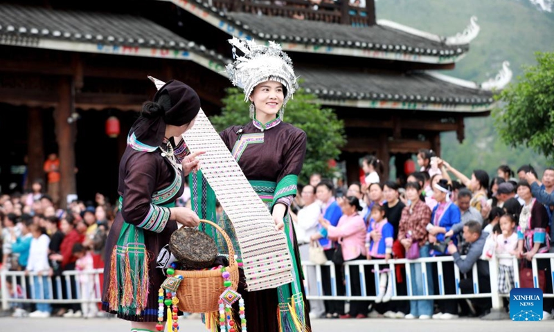 Tourists watch a fashion show featuring intangible cultural heritage elements in Sanjiang Dong Autonomous County, south China's Guangxi Zhuang Autonomous Region, May 2, 2026.(Photo by Gong Pukang/Xinhua)