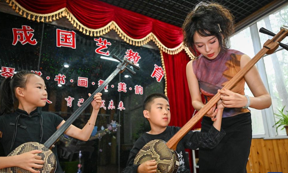 Chu Qiguizi teaches children to play the sanxian at her studio in Tianjin, north China, April 21, 2026. (Xinhua/Sun Fanyue)
