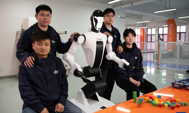 Researchers pose for a photo with a humanoid robot at Youibot Robotics Co., Ltd. in Hefei, east China's Anhui Province, April 29, 2026.(Xinhua/Zhang Duan)
