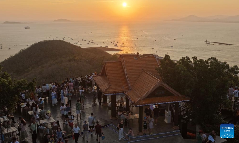 A drone photo taken on May 2, 2026 shows tourists enjoying the sunset glow at Luhuitou scenic area in Sanya, south China's Hainan Province.(Xinhua/Zhao Yingquan)