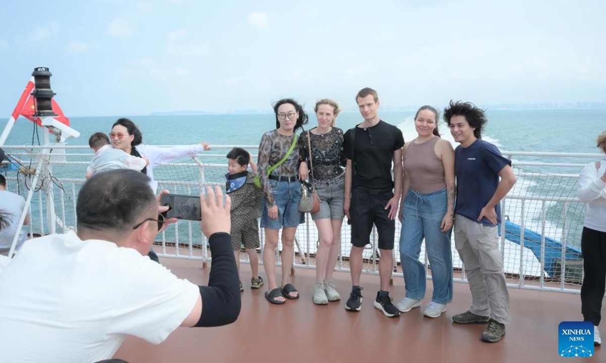 Tourists from Russia and Mexico pose for photos on a passenger ferry heading for Weizhou Island from Beihai in south China's Guangxi Zhuang Autonomous Region, May 1, 2026.
China's inbound tourism booms thanks to visa exemption policies. (Photo by Li Junguang/Xinhua)