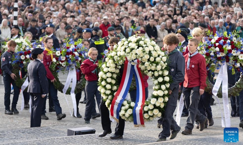 People present wreaths during the commemoration ceremony of the National Remembrance Day on Dam Square in Amsterdam, the Netherlands, May 4, 2026. The National Remembrance Day, observed annually on May 4 in the Netherlands, commemorates civilians and members of the armed forces who have lost their lives in wars and peacekeeping missions. (Photo by Sylvia Lederer/Xinhua)