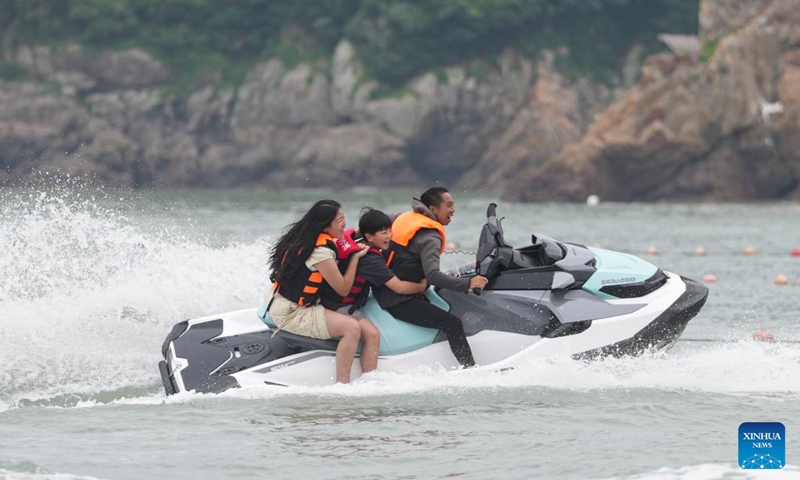 Tourists ride a jet ski in Songmen Town, Wenling City, east China's Zhejiang Province, May 4, 2026. People across China stepped out to fully enjoy their leisure time during the ongoing May Day holiday. (Xinhua/Huang Zongzhi)