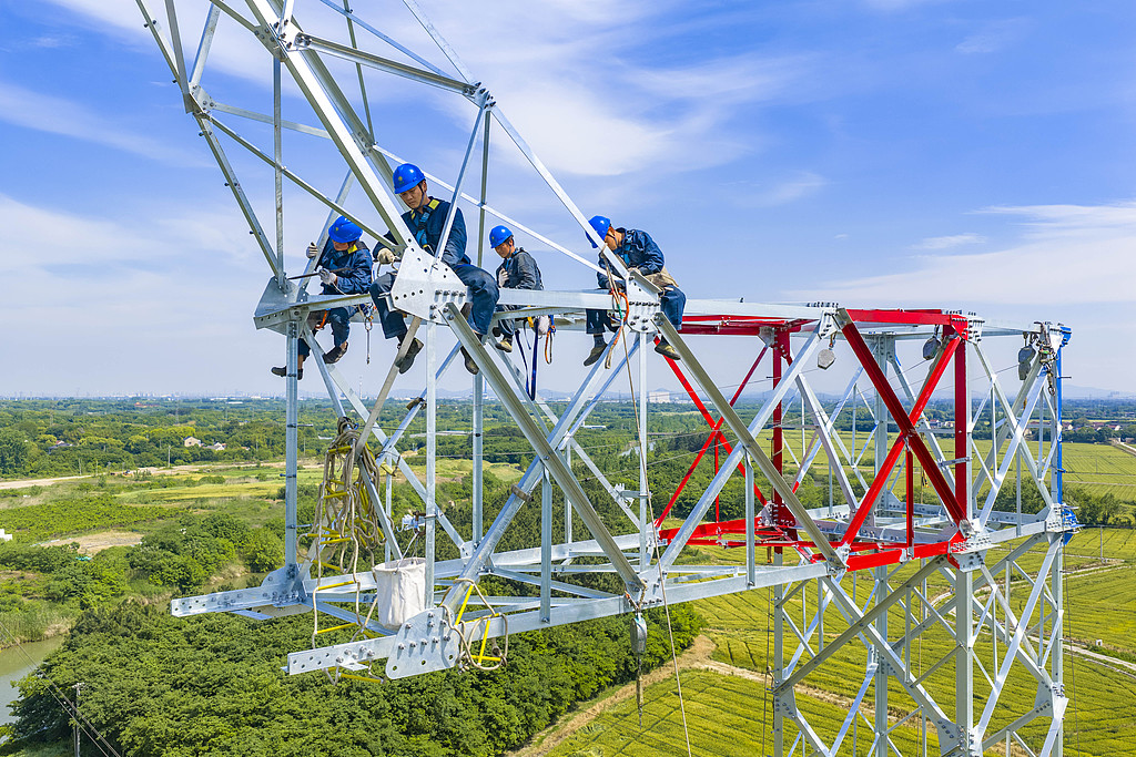 Workers erect a transmission tower at height at the site of the ±500 kV Longzheng Line elevation and reconstruction project in Changzhou, East China's Jiangsu Province, on May 8, 2026. This renovation project will add a new tower between the two existing towers to increase the vertical clearance and the highest navigable water level. Photo: VCG