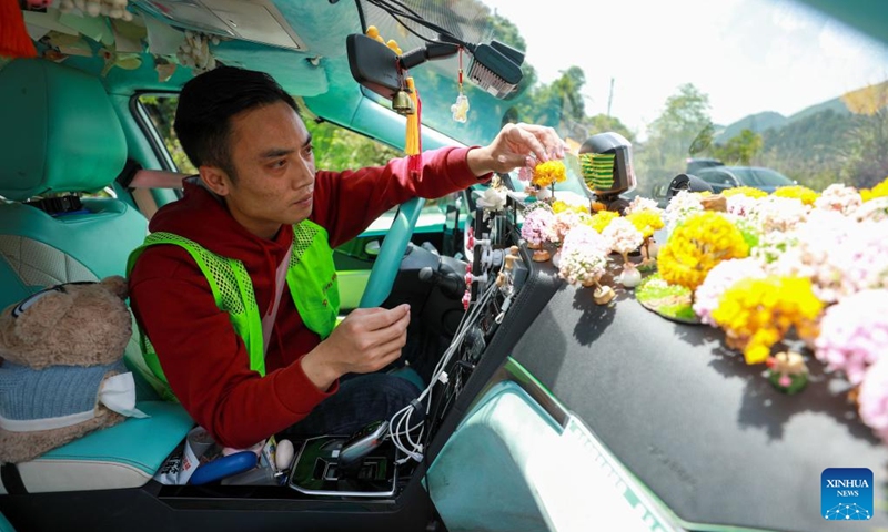 A taxi driver arranges trendy and collectible toys used as decorations inside his car in Duyun, southwest China's Guizhou Province, April 25, 2026. In China, trendy and collectible toys have evolved from a niche hobby into a cultural phenomenon, appearing in a wide range of daily scenarios. These toys not only provide an outlet for personal expression and a means of social connection, but also bear witness to a trend in consumption that emphasizes the pursuit of individuality. (Photo: Xinhua)