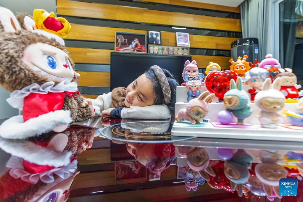 A girl fiddles with her collection of trendy and collectible toys at home in Bijie, southwest China's Guizhou Province, April 26, 2026. In China, trendy and collectible toys have evolved from a niche hobby into a cultural phenomenon, appearing in a wide range of daily scenarios. These toys not only provide an outlet for personal expression and a means of social connection, but also bear witness to a trend in consumption that emphasizes the pursuit of individuality. (Photo: Xinhua)
