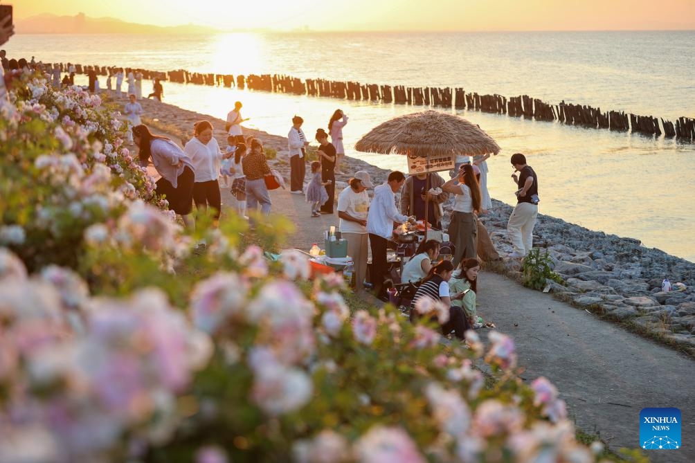 Tourists have fun amid blooming flowers during the May Day holiday in Huzhou, east China's Zhejiang Province, May 5, 2026. (Photo: Xinhua)