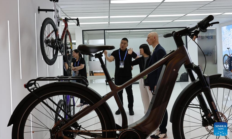 A staff member introduces a bicycle to visitors at the 2026 China International Bicycle Fair in east China's Shanghai, May 6, 2026. The four-day 2026 China International Bicycle Fair kicked off at Shanghai New International Expo Centre on Tuesday. (Xinhua/Fang Zhe)

