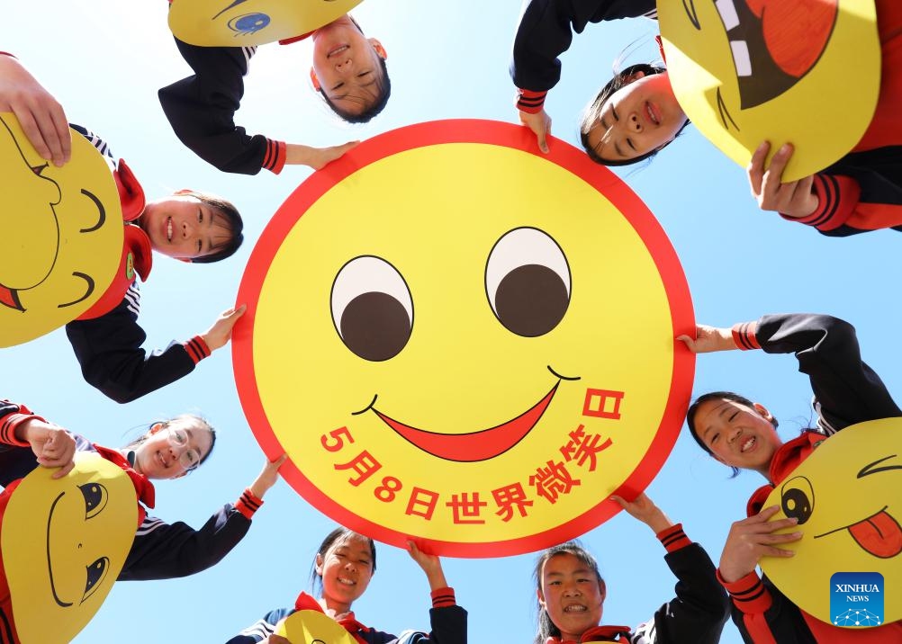 Students show smiling face props at a primary school in Tangshan City, north China's Hebei Province, May 7, 2026. May 8 marks the World Smile Day. (Photo by Zhu Dayong/Xinhua)

